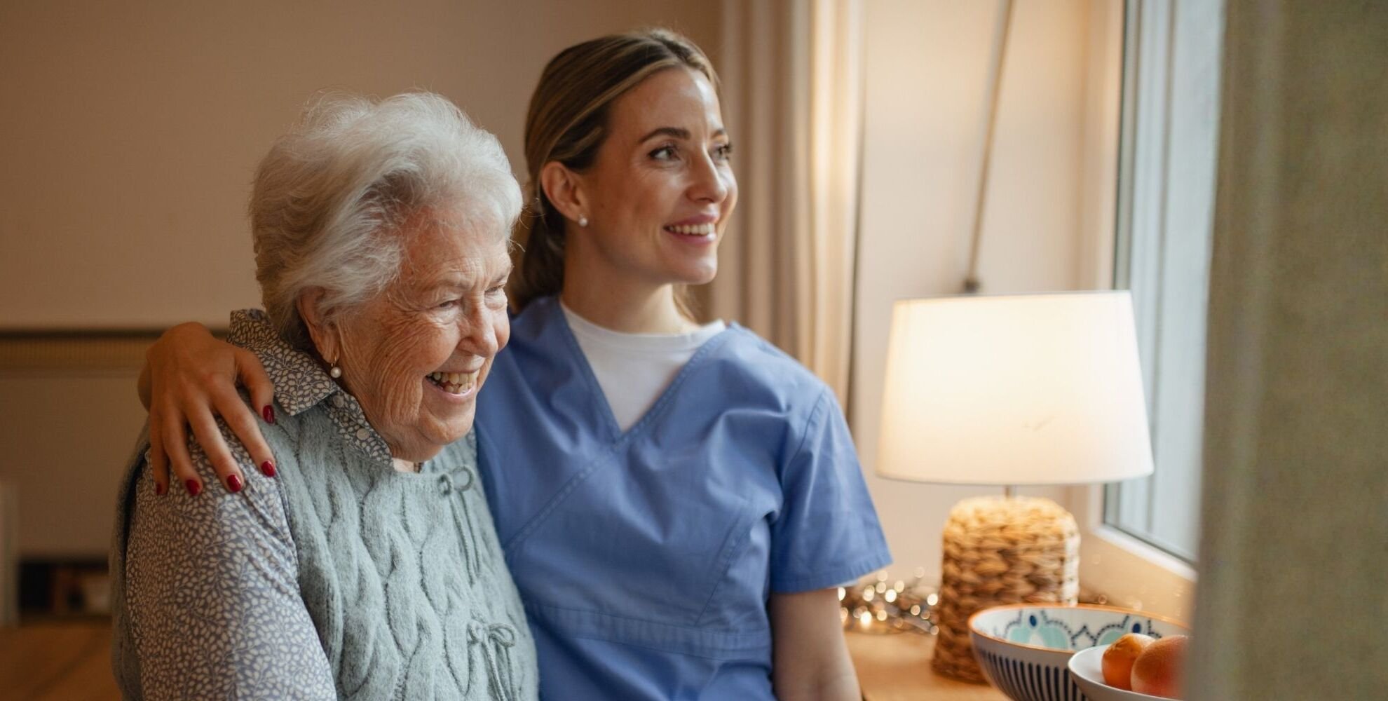 Senior woman and care attendant sitting