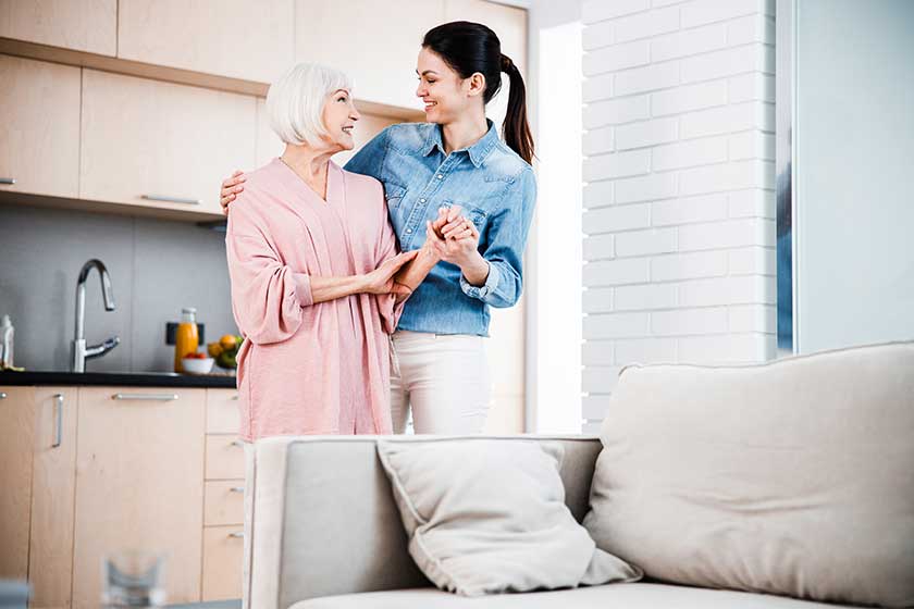 Joyful young woman hugging grandmother