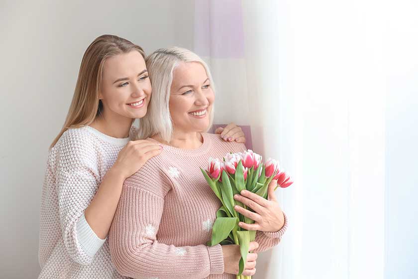 Young daughter and mother with bouquet of flowers